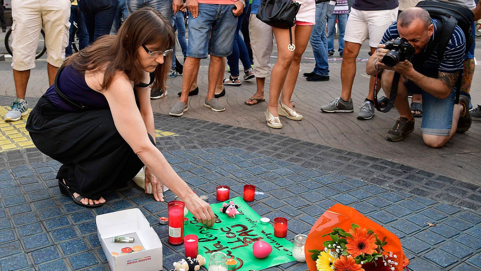 Una mujer deposita flores en memoria de las víctimas del atentado de Las Ramblas.