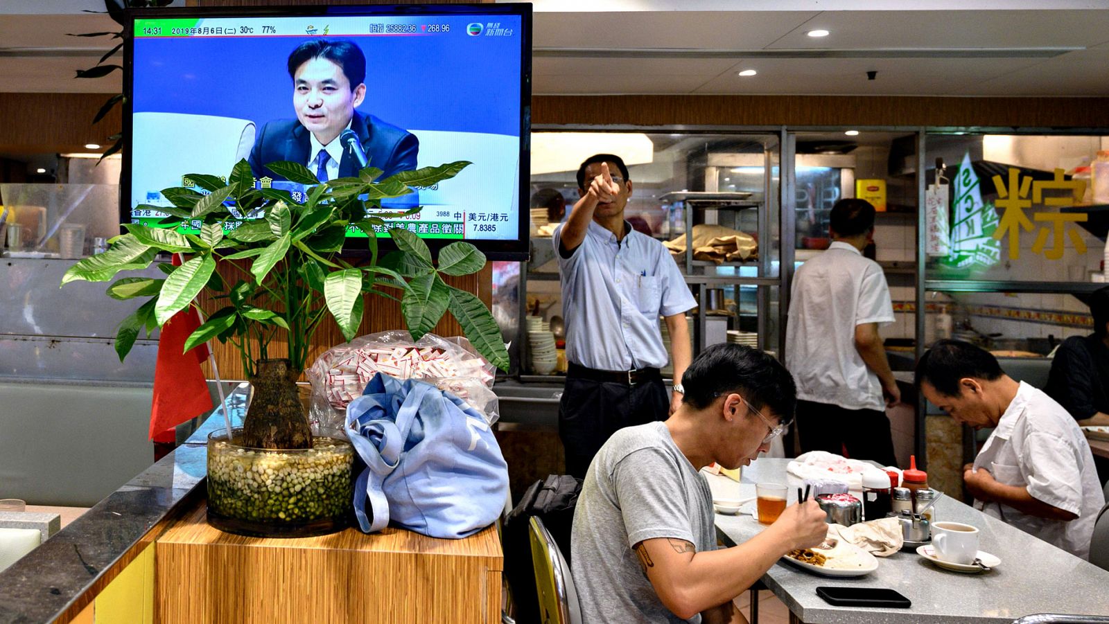 Una televisión muestra la rueda de prensa del portavoz del Gobierno chino, Yang Guang, en un restaurante de Hong Kong