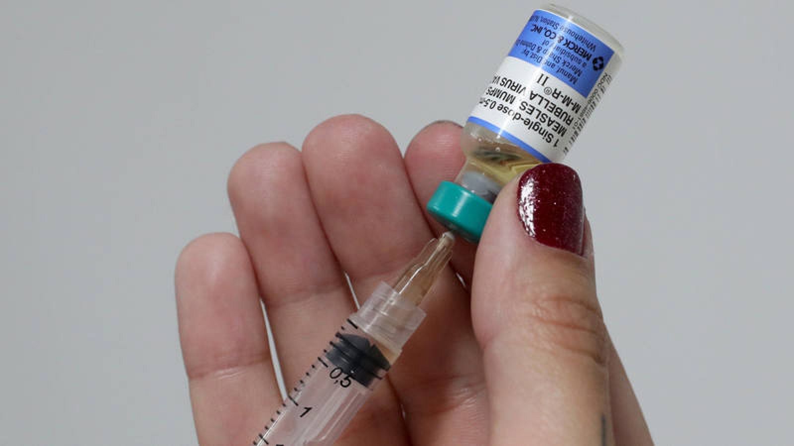 Una doctora aplica una inyección contra el sarampión