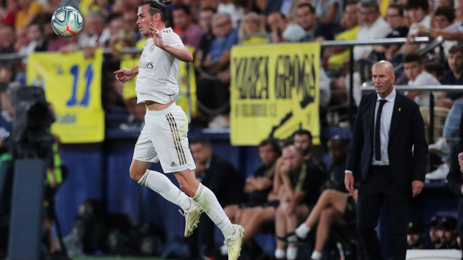 Bale controla un balón ante la mirada de Zidane