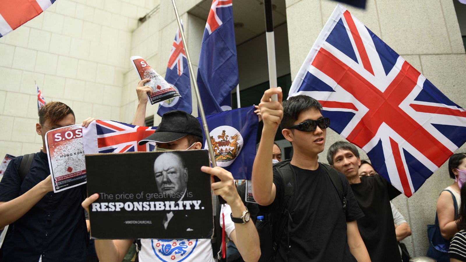 Un manifestante sostiene una pancarta con la imagen de Churchill y su famosa cita: "El precio de la grandeza es la responsabilidad".