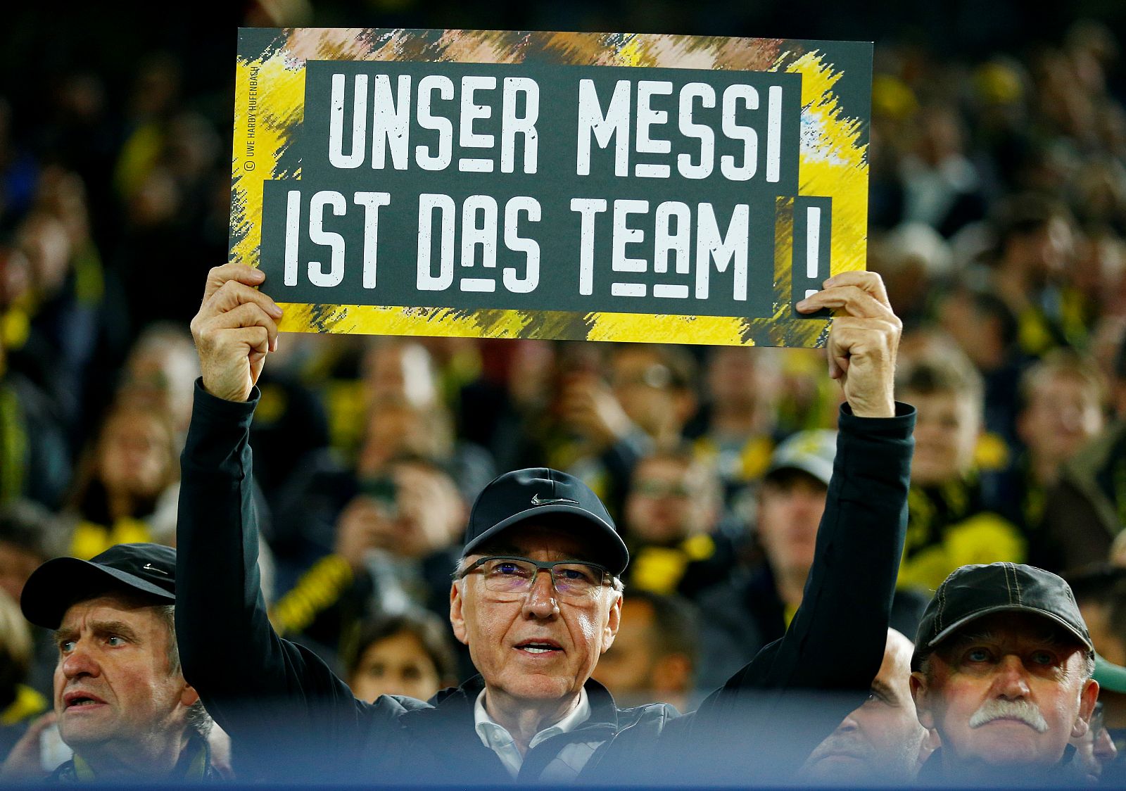 Un aficionado del Dortmund muestra una pancarta que dice en alemán: "Nuestro Messi es el equipo"