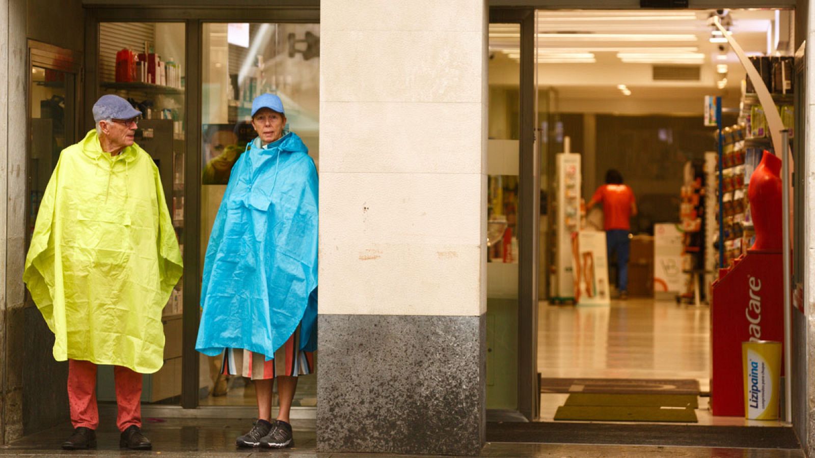 Dos turistas se protegen de la lluvia en Vitoria