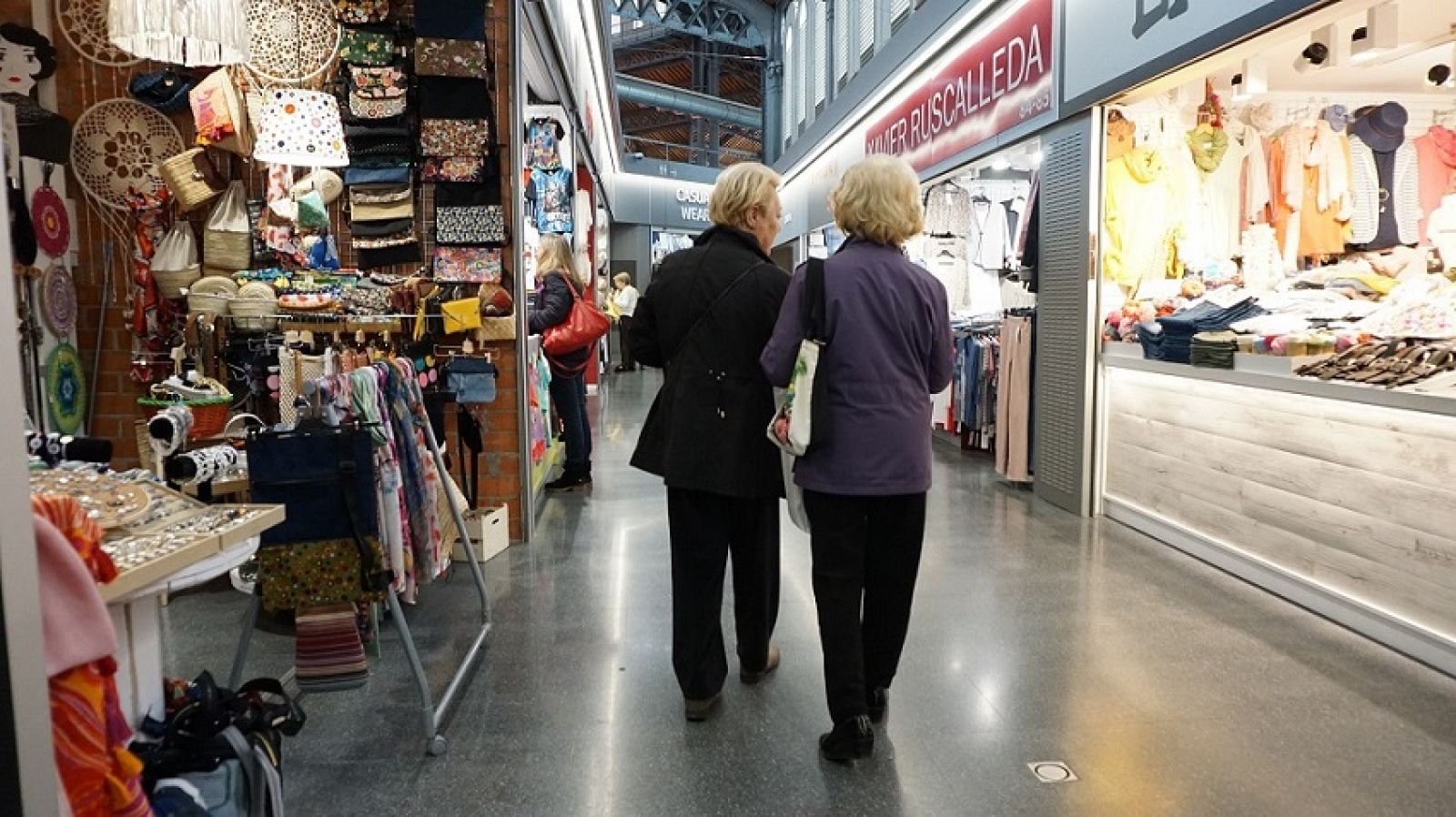 Unes senyores passegen per les parades interiors del Mercat de Sant Antoni