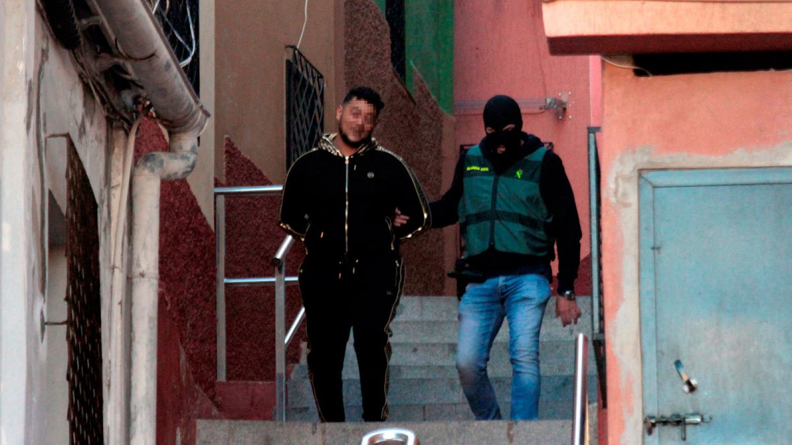 Un miembro de la Guardia Civil con uno de los detenidos durante la operación contra el tráfico de drogas y de inmigrantes en Ceuta