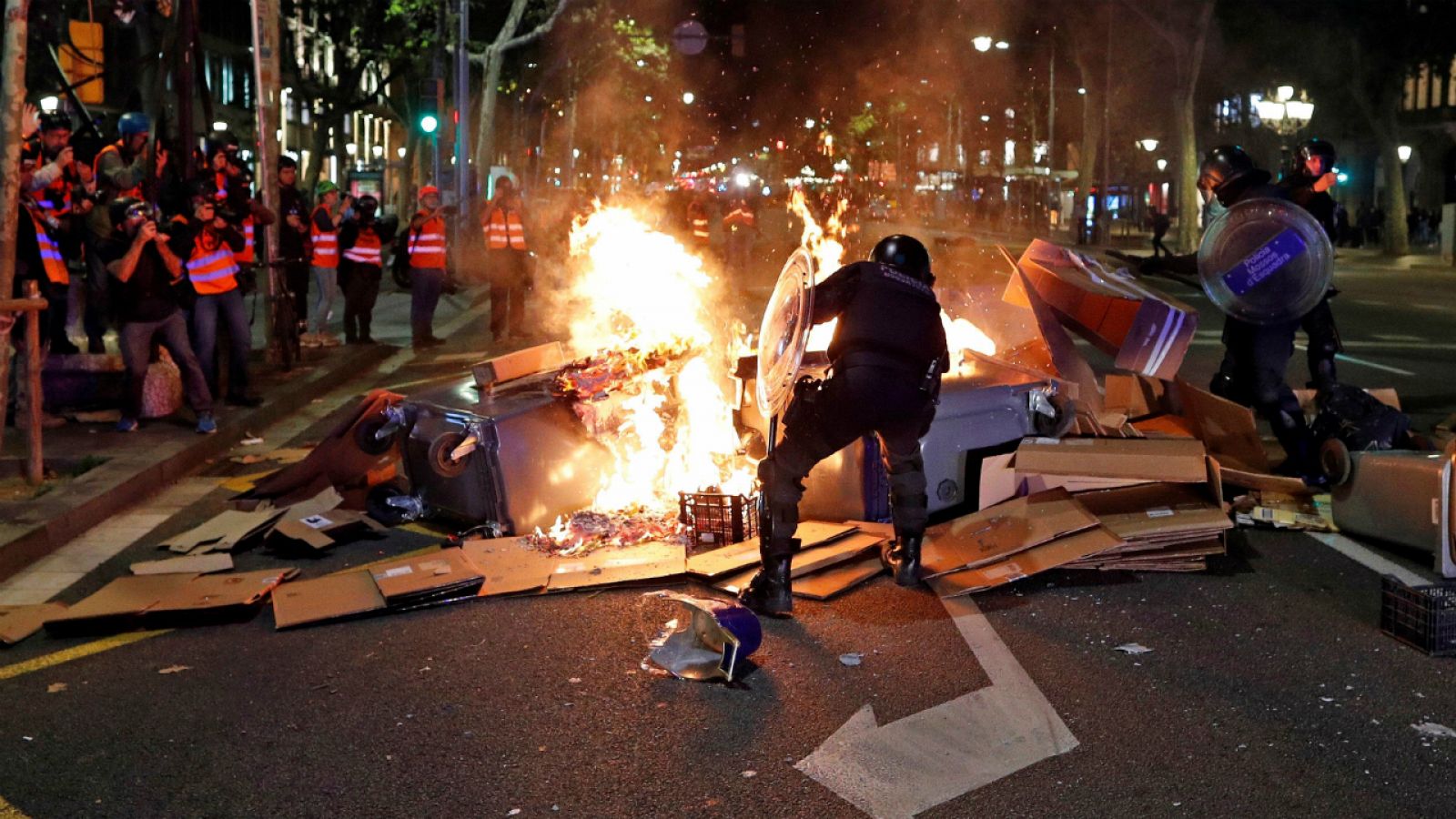 Dos agentes tratan de controlar una barricada en Barcelona