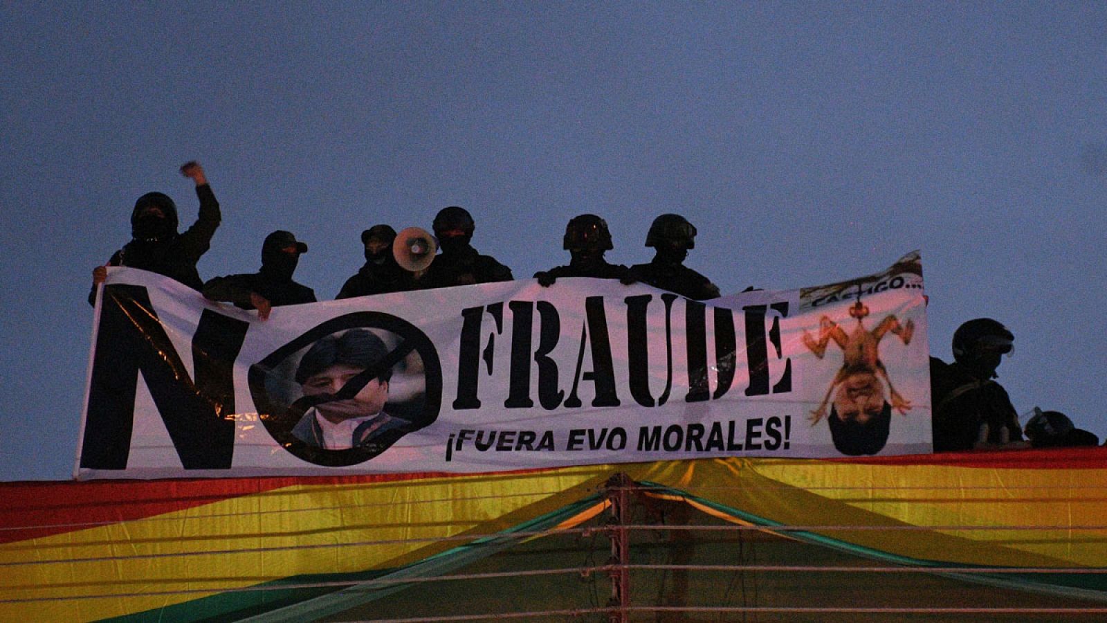 Policías bolivianos desplegando una pancarta contra Evo Morales en el techo de una unidad policial en Cochabamba.
