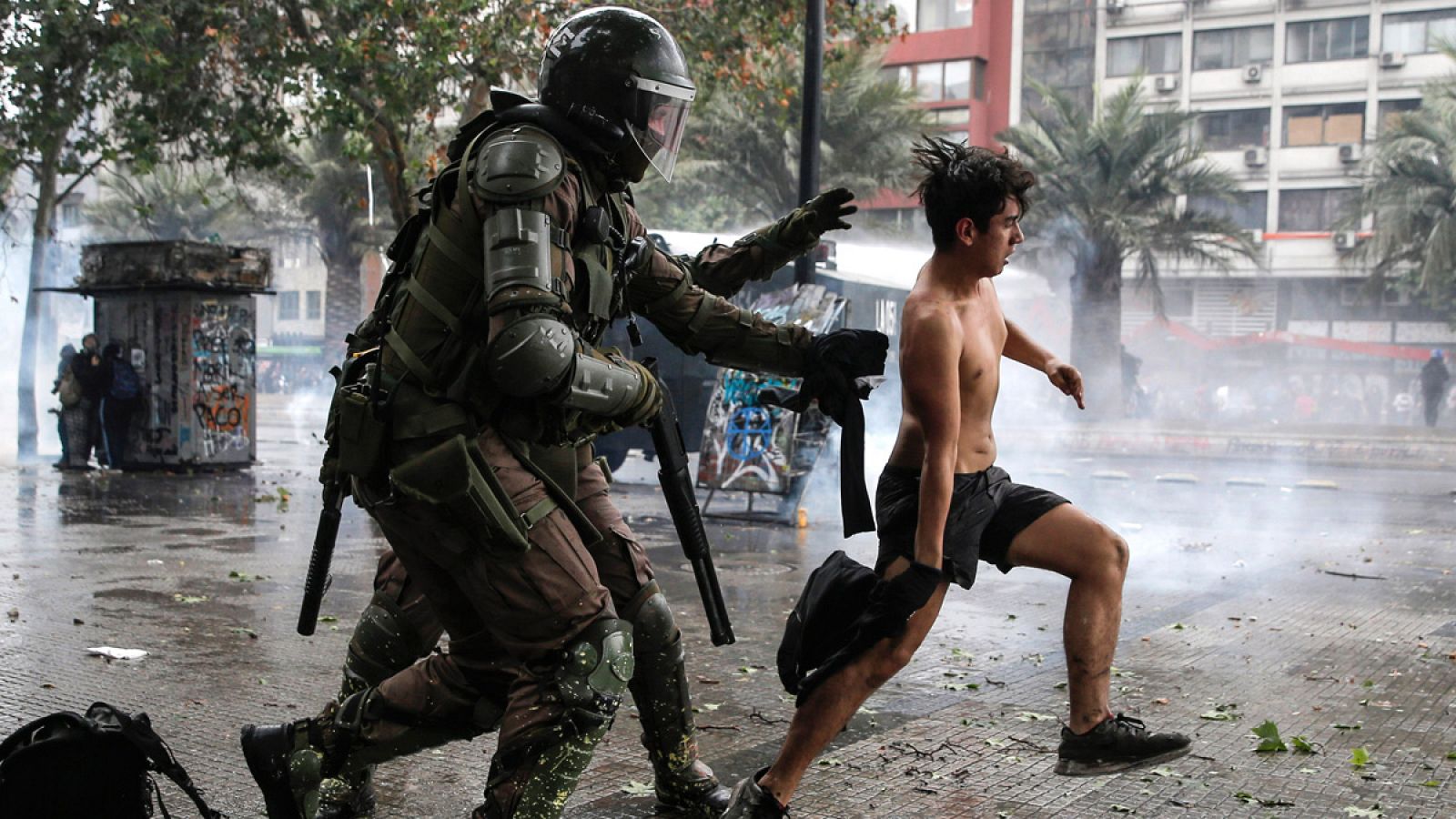 Policías antidisturbios persiguen a un manifestante en Santiago