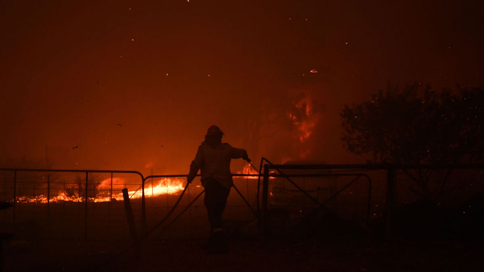 Un miembro del Servicio Rural de Incendios (RFS) intentando proteger un terreno del fuego cerca de la ciudad de Tahmoor, Nueva Gales del Sur, Australia.