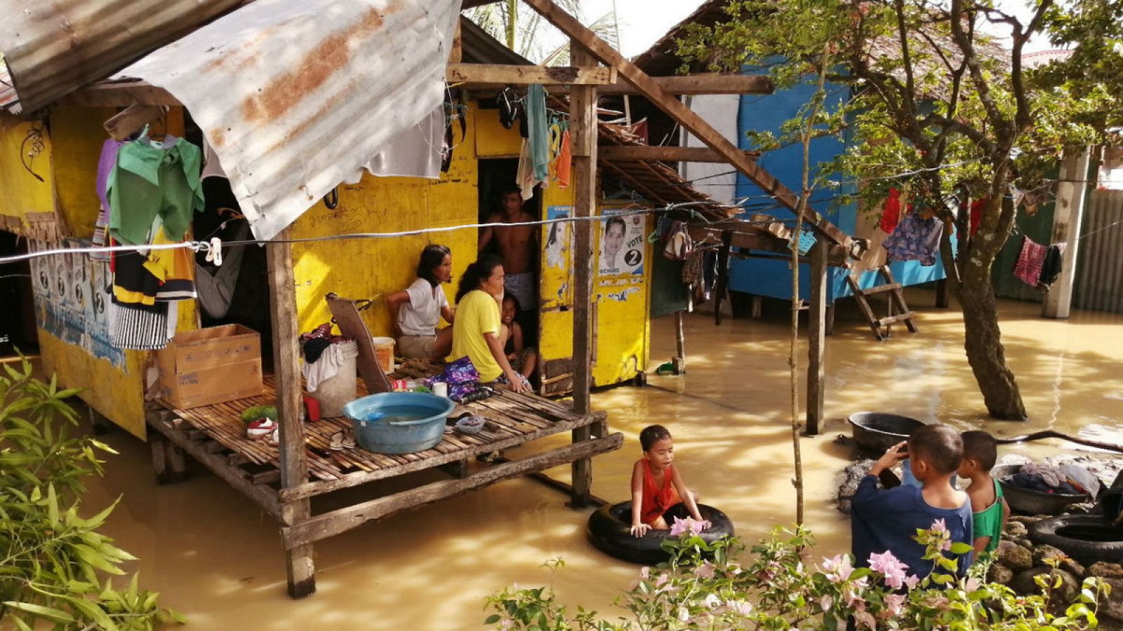 Lugareños junto a una inundación en pleno azote del tifón Phanfone.