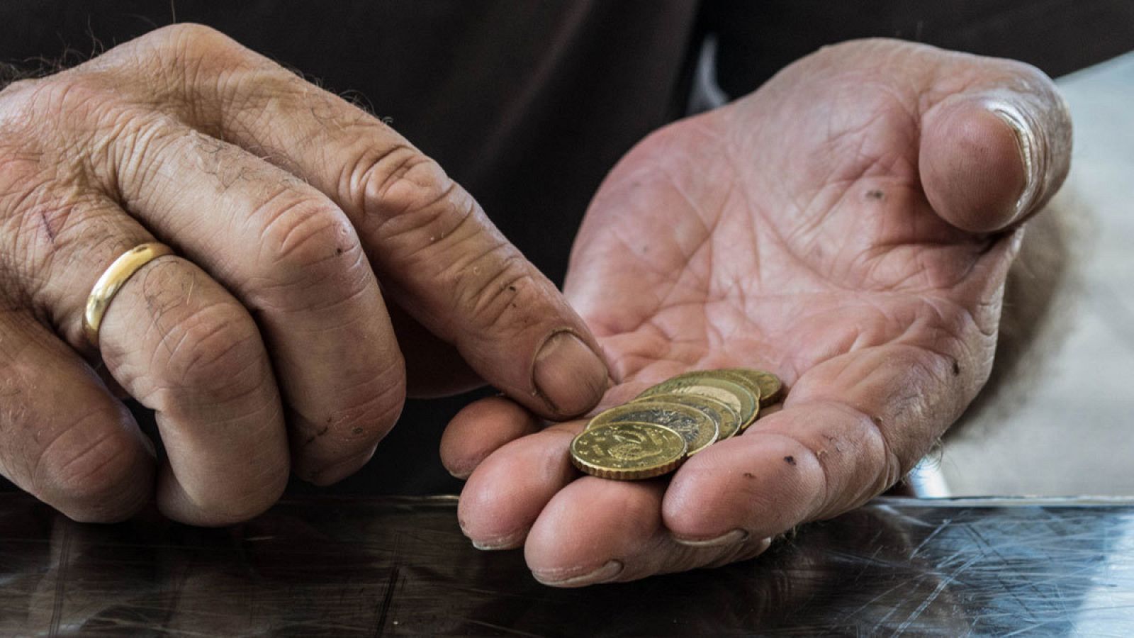 Un hombre cuenta monedas en su mano