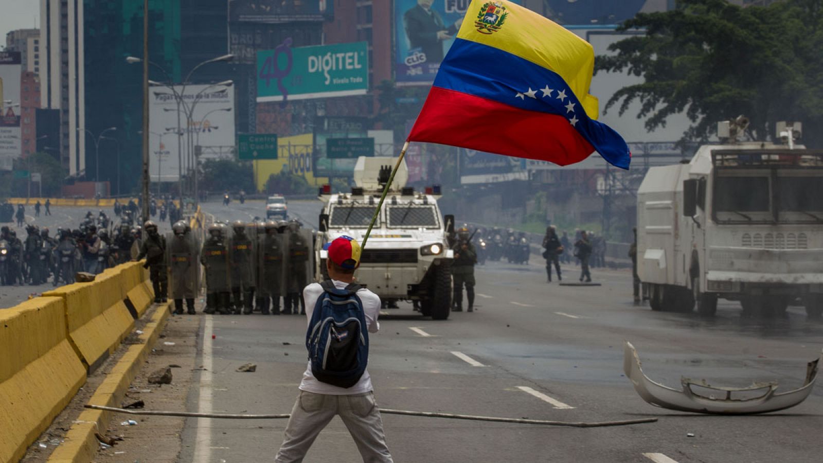 Imagen de archivo de un joven manifestándose en Caracas ondeando una bandera venezolana en frente de miembros de la Guardia Nacional.