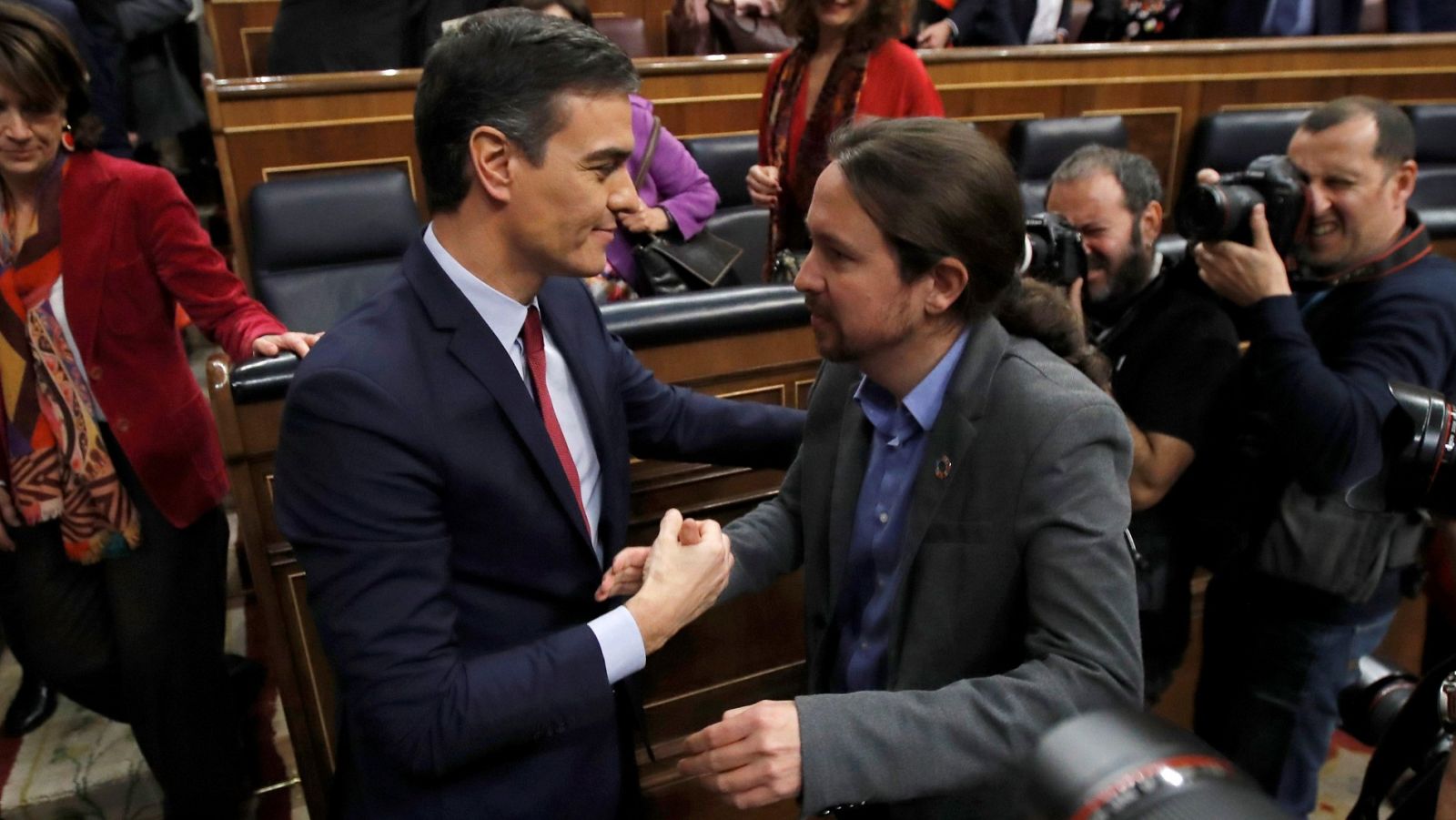 El líder de Unidas Podemos, Pablo Iglesias, felicita a Pedro Sánchez, quien ha logrado la confianza del Congreso para un nuevo mandato como presidente del Gobierno.