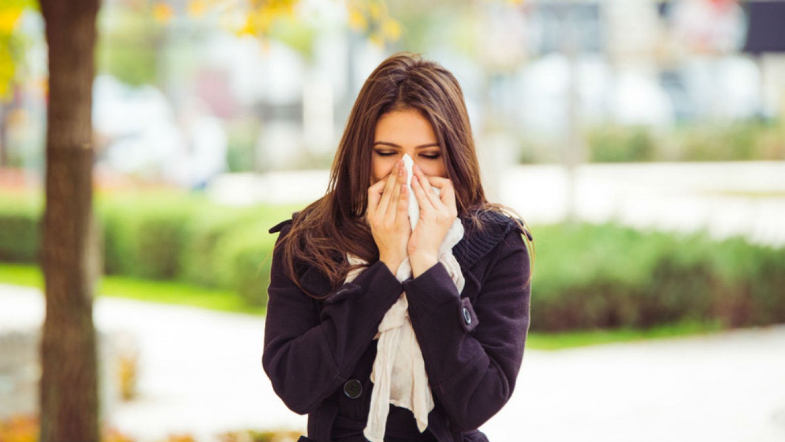 Una mujer estornuda, uno de los síntomas de la rinitis, que afecta a gran parte de la población mundial.