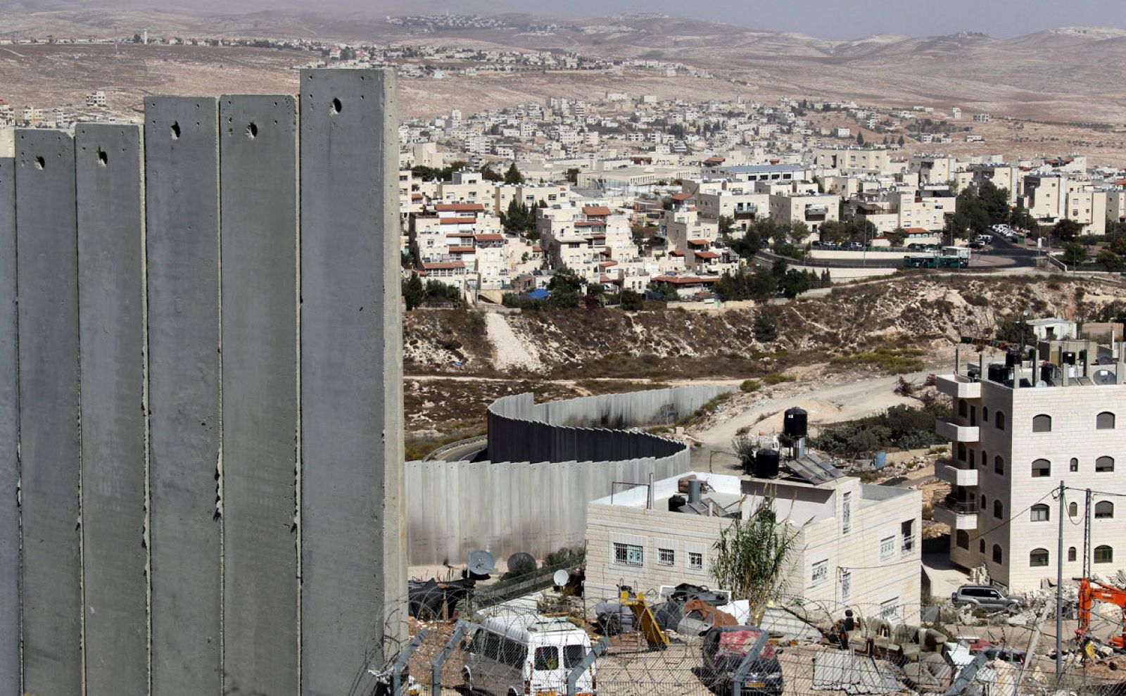 Vista de un fragmento del muro de separación, de parte de la colonia de Pisgat Zeev (centro, arriba), un asentamiento en rápido crecimiento que Israel considera un barrio de Jerusalén.