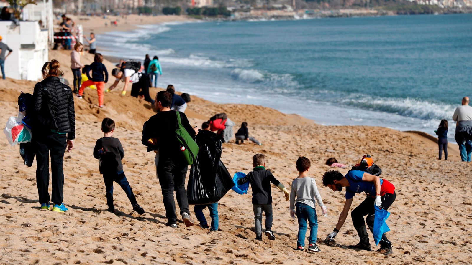 Voluntarios ayudan a limpiar las playas de Badalona tras el paso del temporal 'Gloria