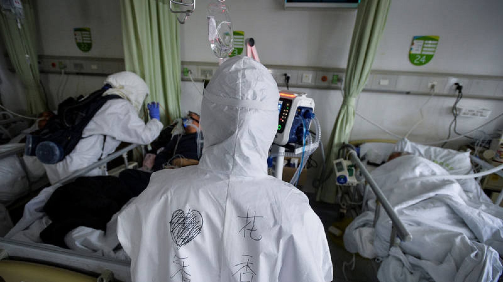 Trabajadores médicos con trajes protectores atendiendo a pacientes con coronavirus dentro de una sala de aislamiento en un hospital en Wuhan, China. 
