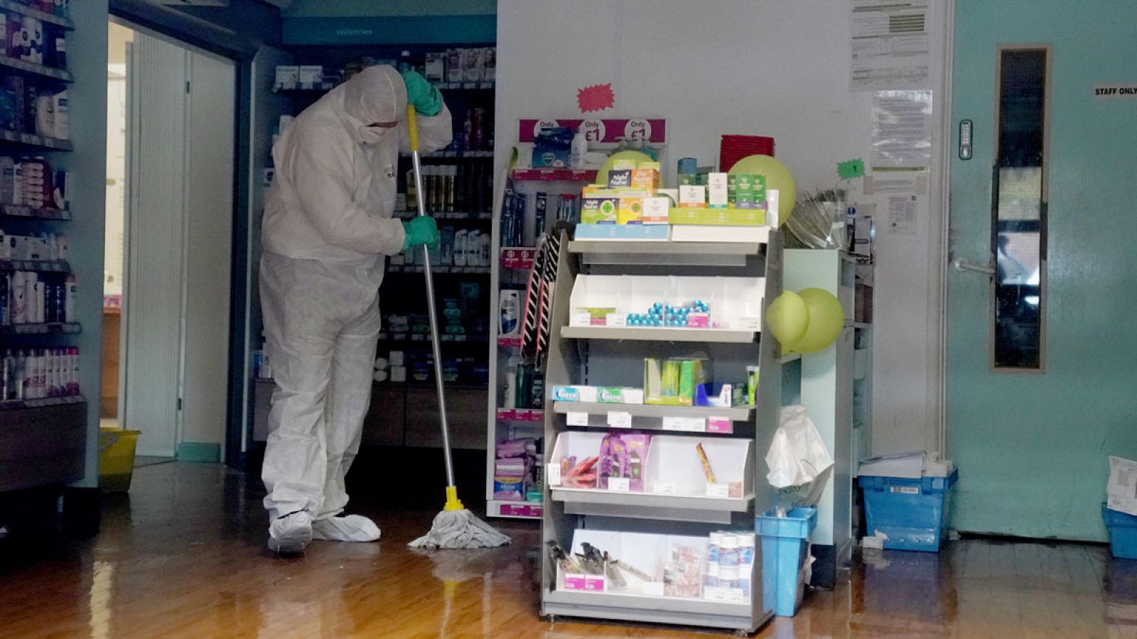 Un trabajador con traje protector limpia el centro médico, cerrado temporalmente en Brighton por coronavirus. 