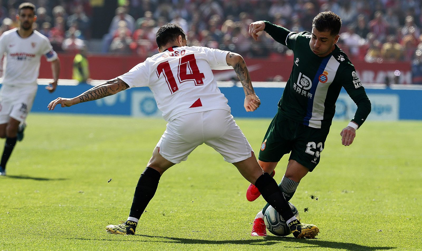 El delantero del Espanyol Adrián Embarba (d) trata de marcharse del centrocampista del Sevilla Suso Fernández (i),
