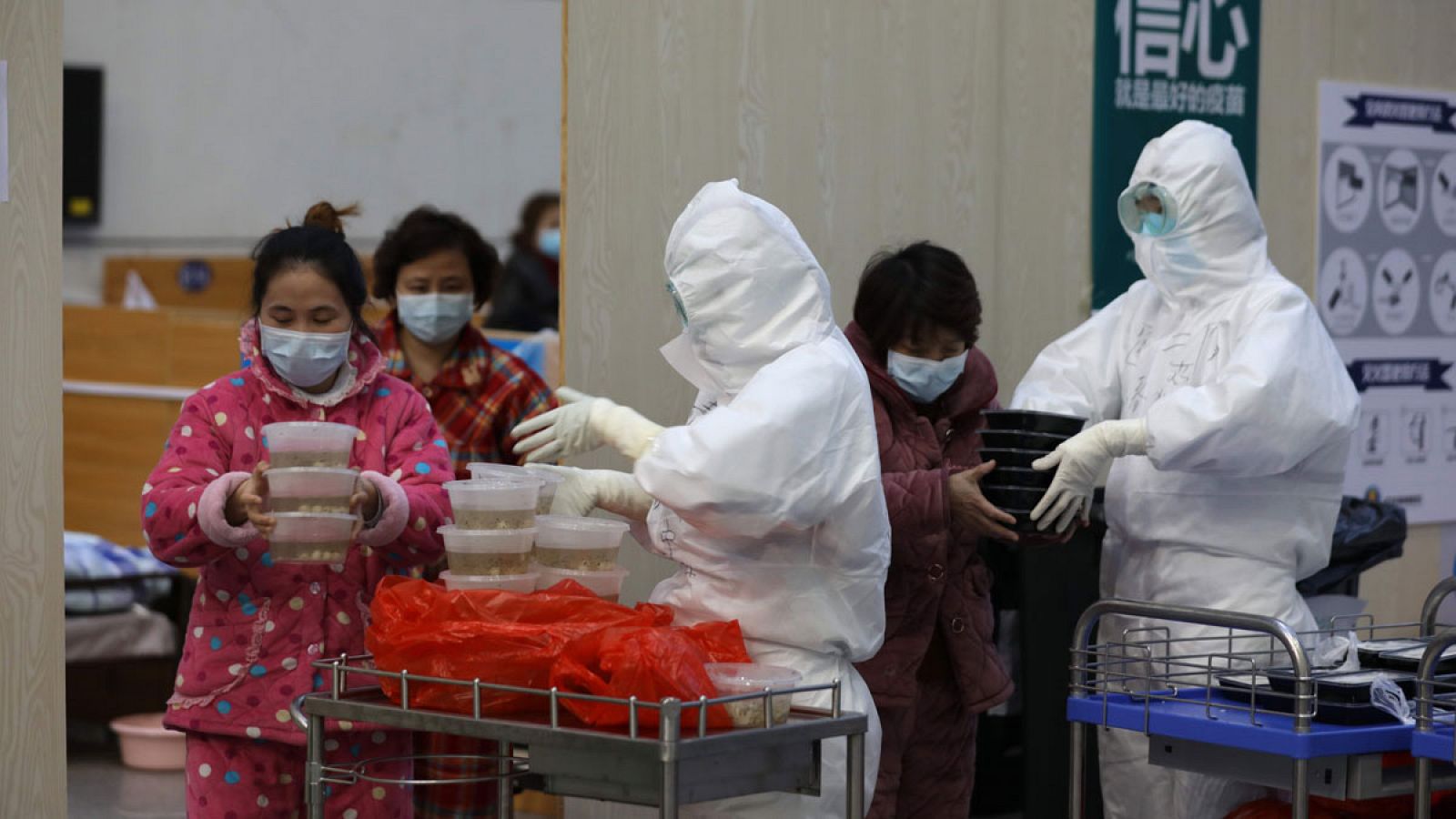 Personal sanitario repartiendo comida a pacientes con coronavirus en un hospital de Wuhan, China.