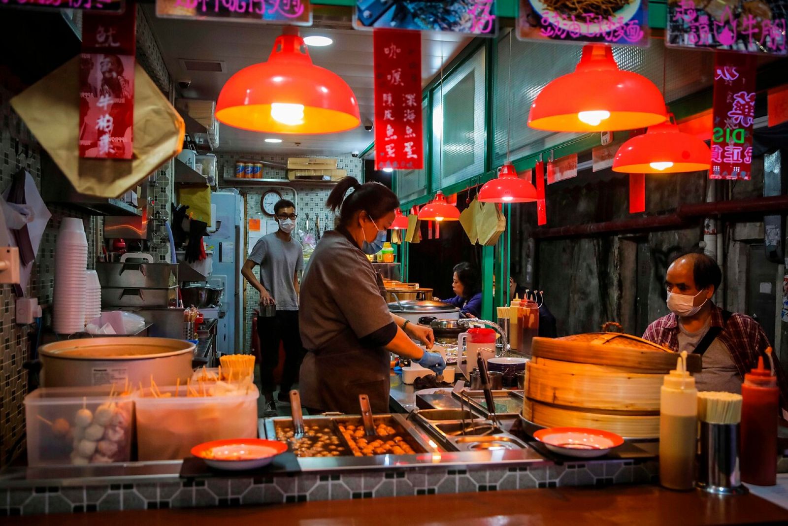 Trabajadores y consumidores utilizan mascarillas en un mercado de Hong Kong