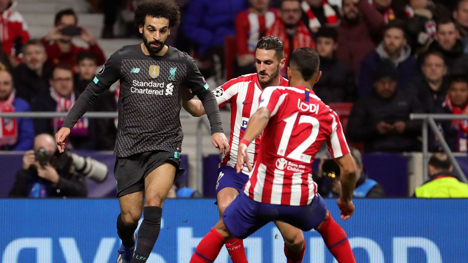 El delantero del Liverpool Mohamed Salah intenta escaparse de los jugadores del Atlético Renan Lodi y Koke.