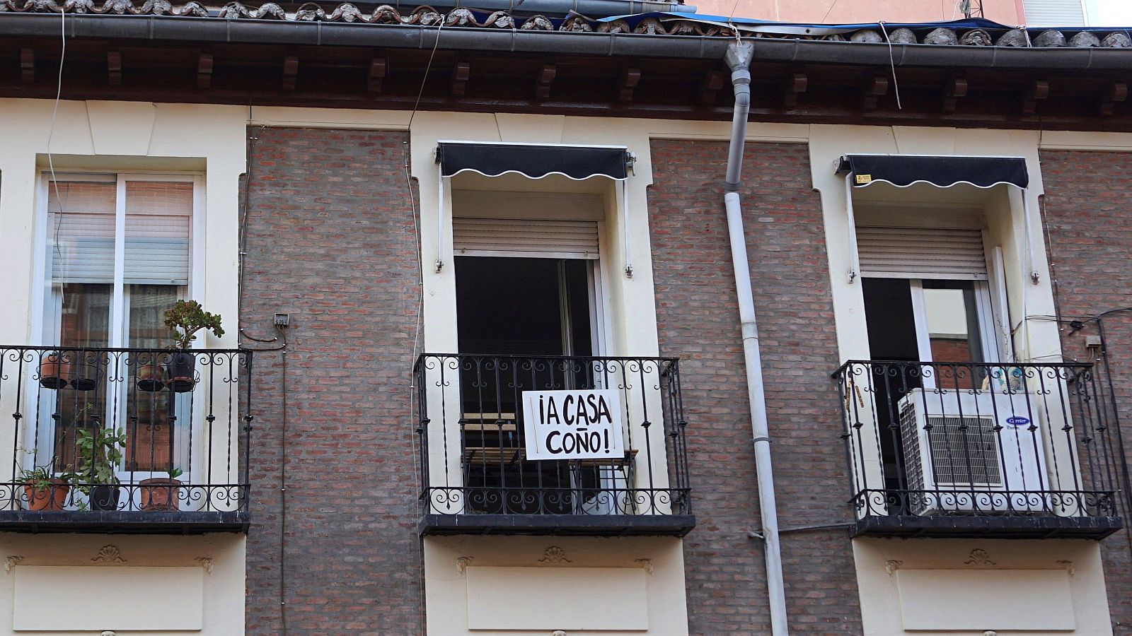 Un cartel colgado en un balcón pide a sus vecinos que se queden en casa para evitar los contagios.