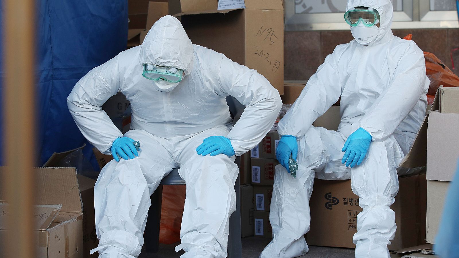 Dos trabajadores sanitarios surcoreanos descansan después de realizar decenas de pruebas para el coronavirus.