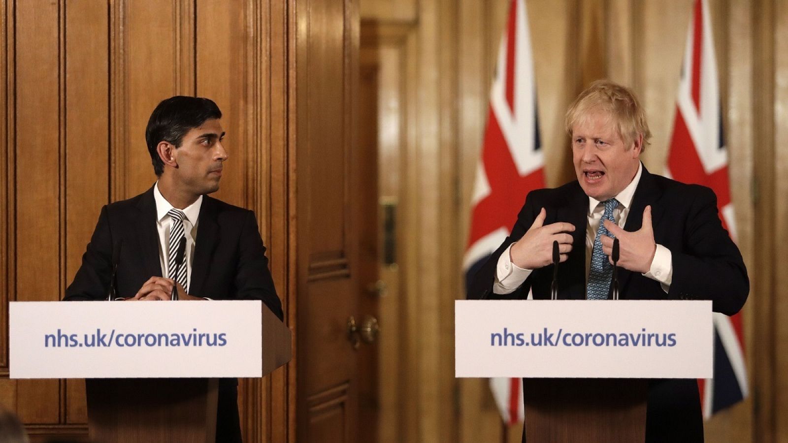 El primer ministro británico, Boris Johnson (d), junto al ministro de Economía, Rishi Sunak, durante la rueda de prensa que han ofrecido.