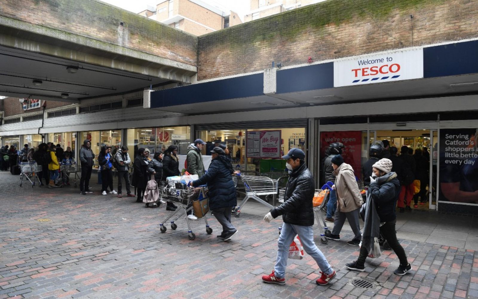 Gente esperando en fila para hacer la compra en un supermercado en el sur de Londres, Reino Unido