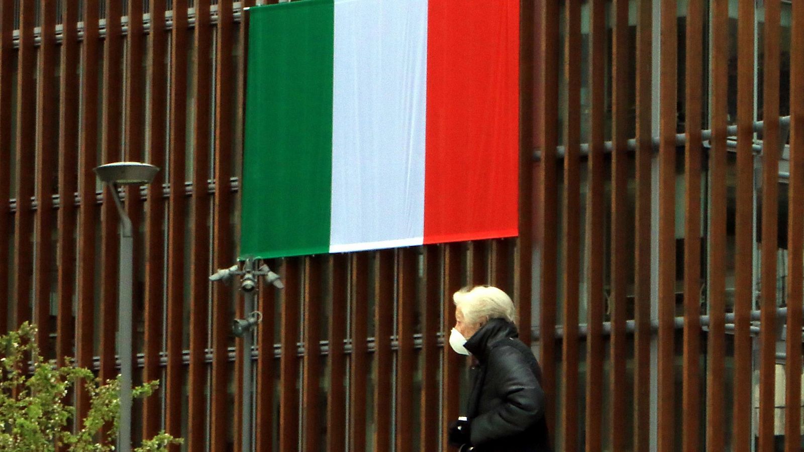 Una bandera italiana ondea en un edificio en Milán.