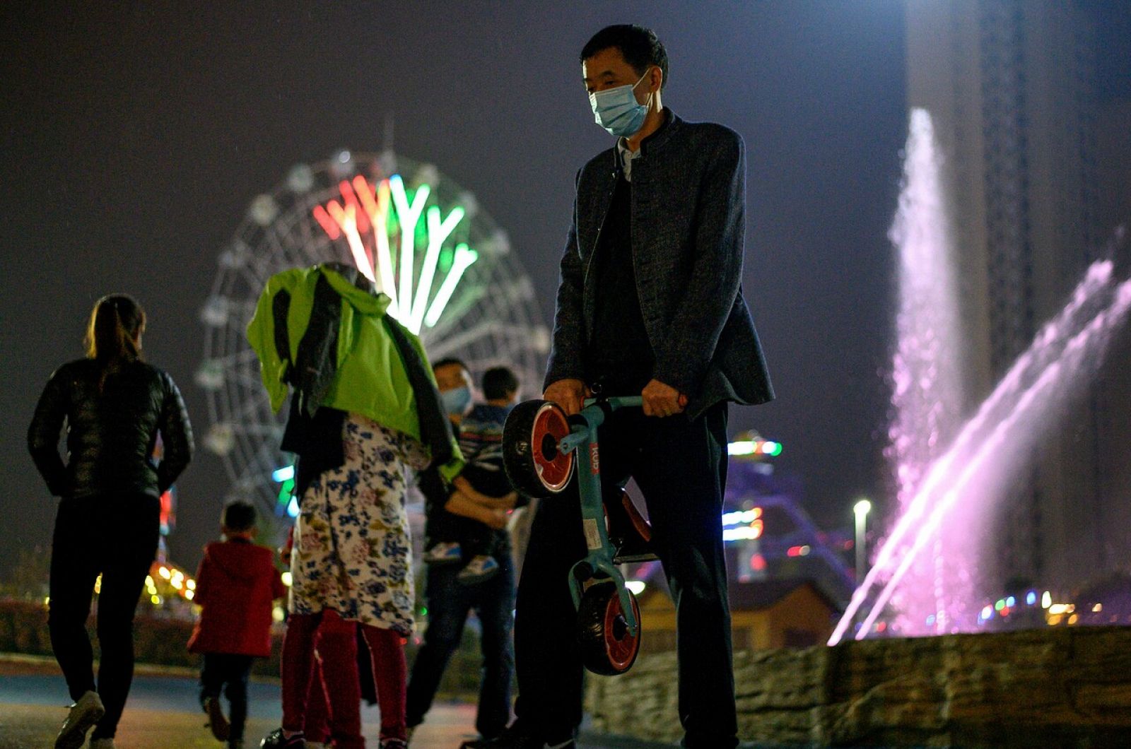 Personas con mascarillas en un parque temático de Macheng, Hubei