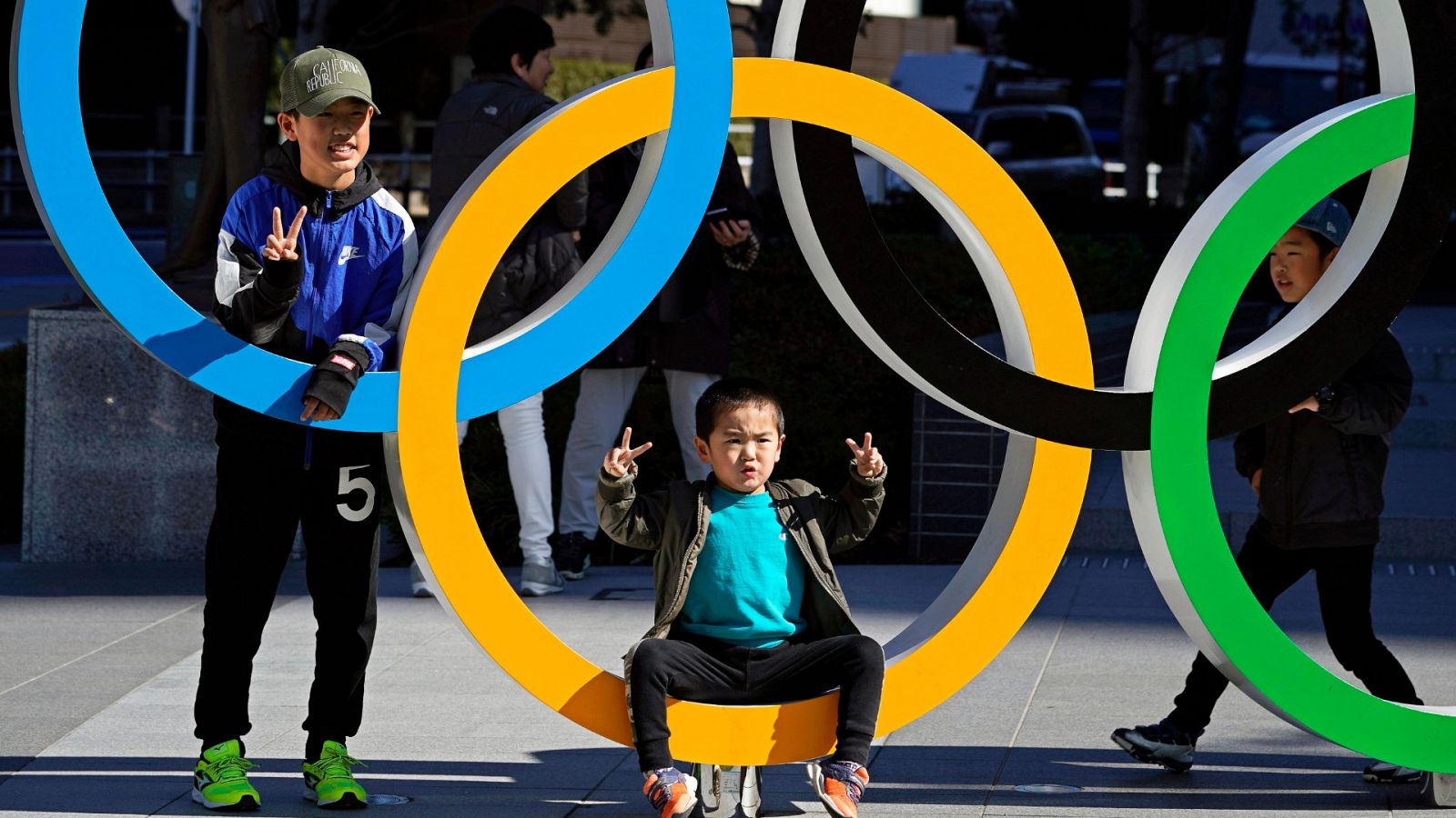 Un niño posa para una foto en uno de los aros olímpicos