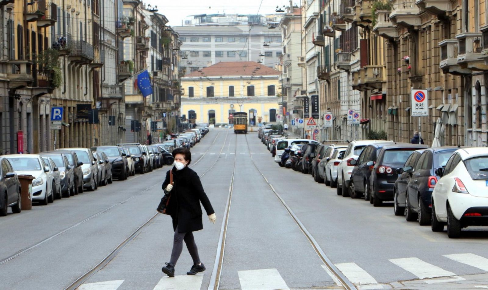 Una mujer camina por una calle desierta en Milán