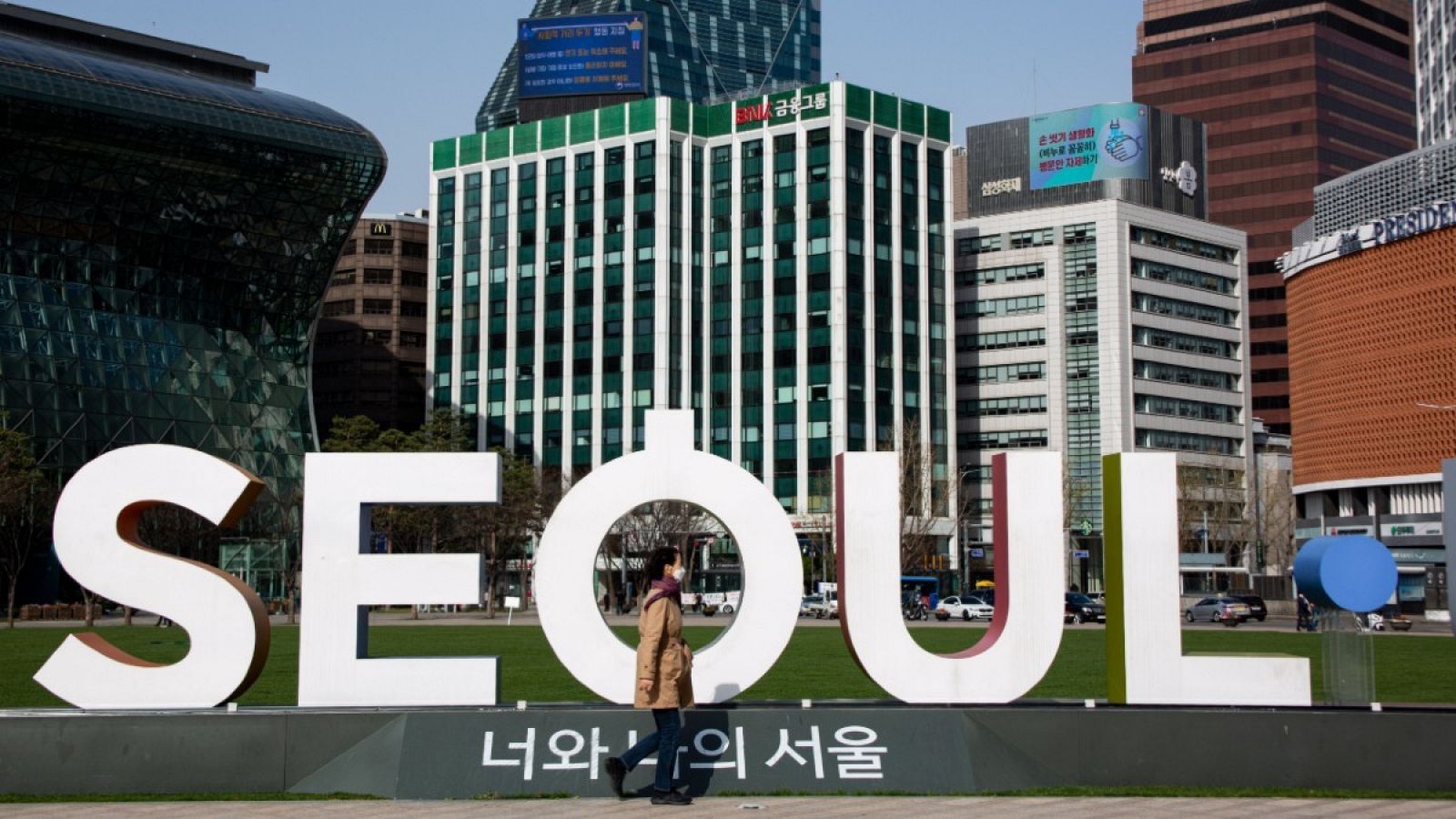 Una mujer con mascarilla caminando por una calle de Seúl, Corea del Sur. 
