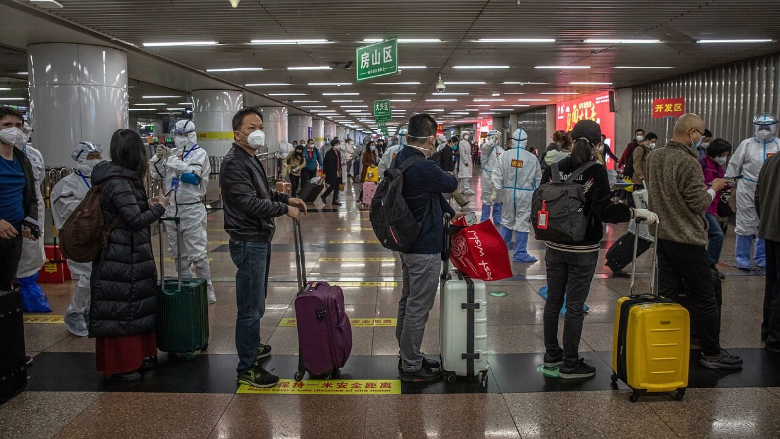 Pasajeros procedentes de Wuhan forman filas en la estación de tren de Pekín