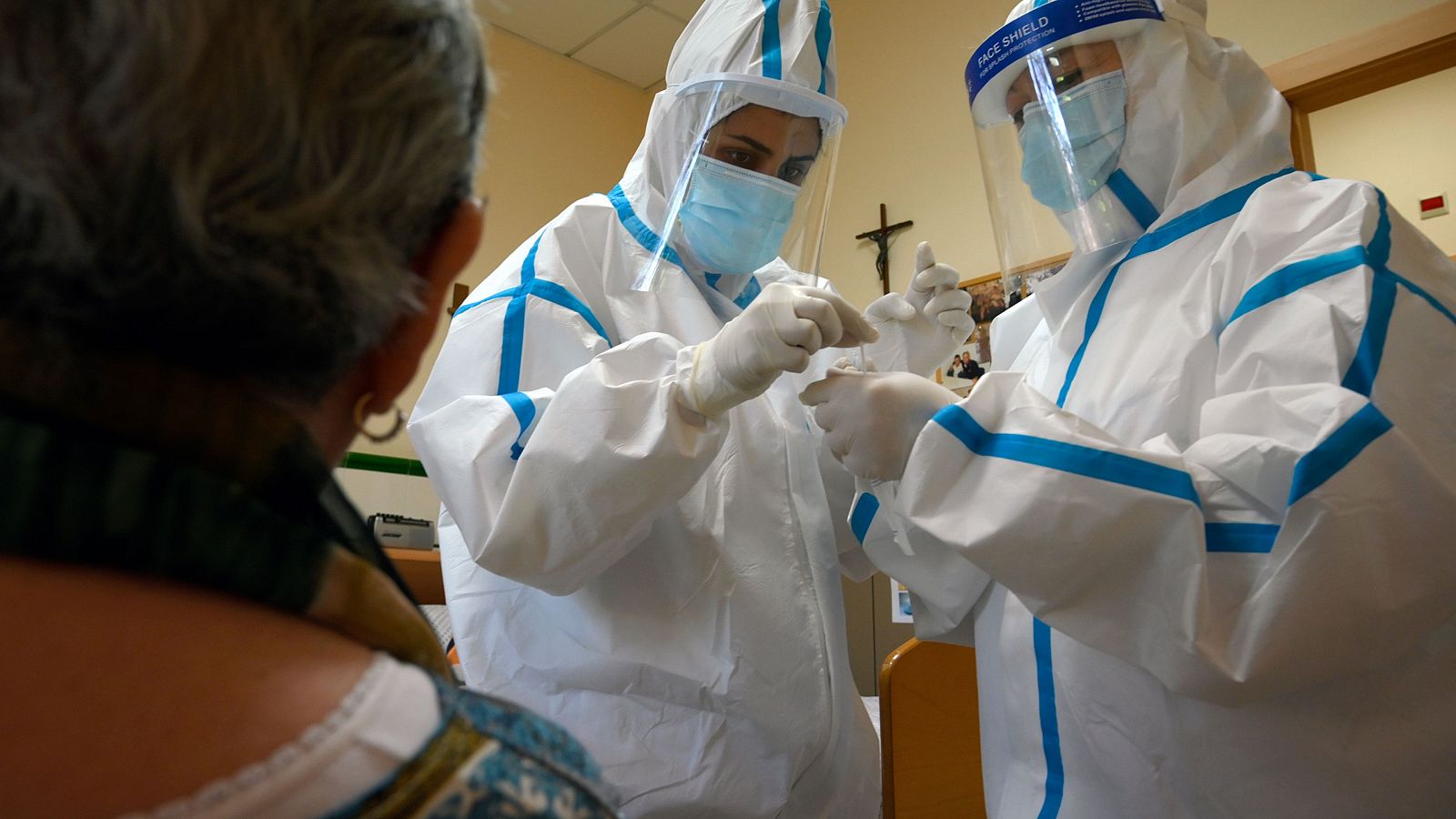 Profesionales sanitarios con trajes protectores toman una muestra para una prueba de Covid-19 en el Hospital Sant Miquel de Barcelona.