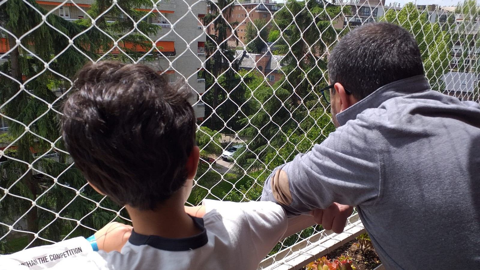 Nicolás, de 7 años, mira junto a su padre la calle pensando ya en las cosas que podrá hacer cuando salga.