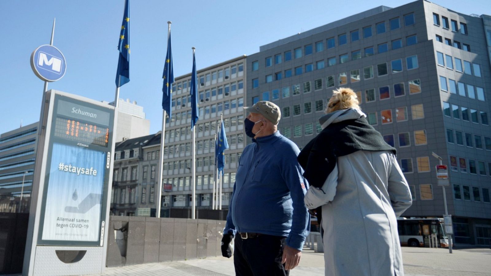 Una pareja con mascarillas frente a la sede de la Comisión Europea en Bruselas, Bélgica.