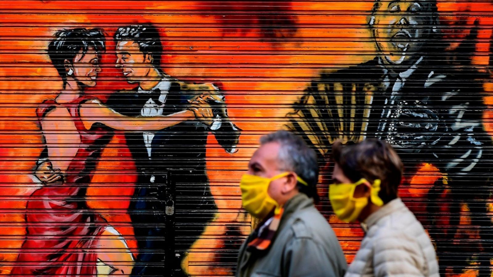 Dos personas con mascarilla caminando por una calle de Buenos Aires, Argentina.