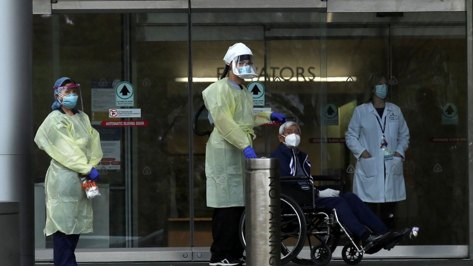 Personal sanitario acompañando a un paciente a su salida del Hospital Johns Hopkins en Baltimore, Maryland (EE.UU.).