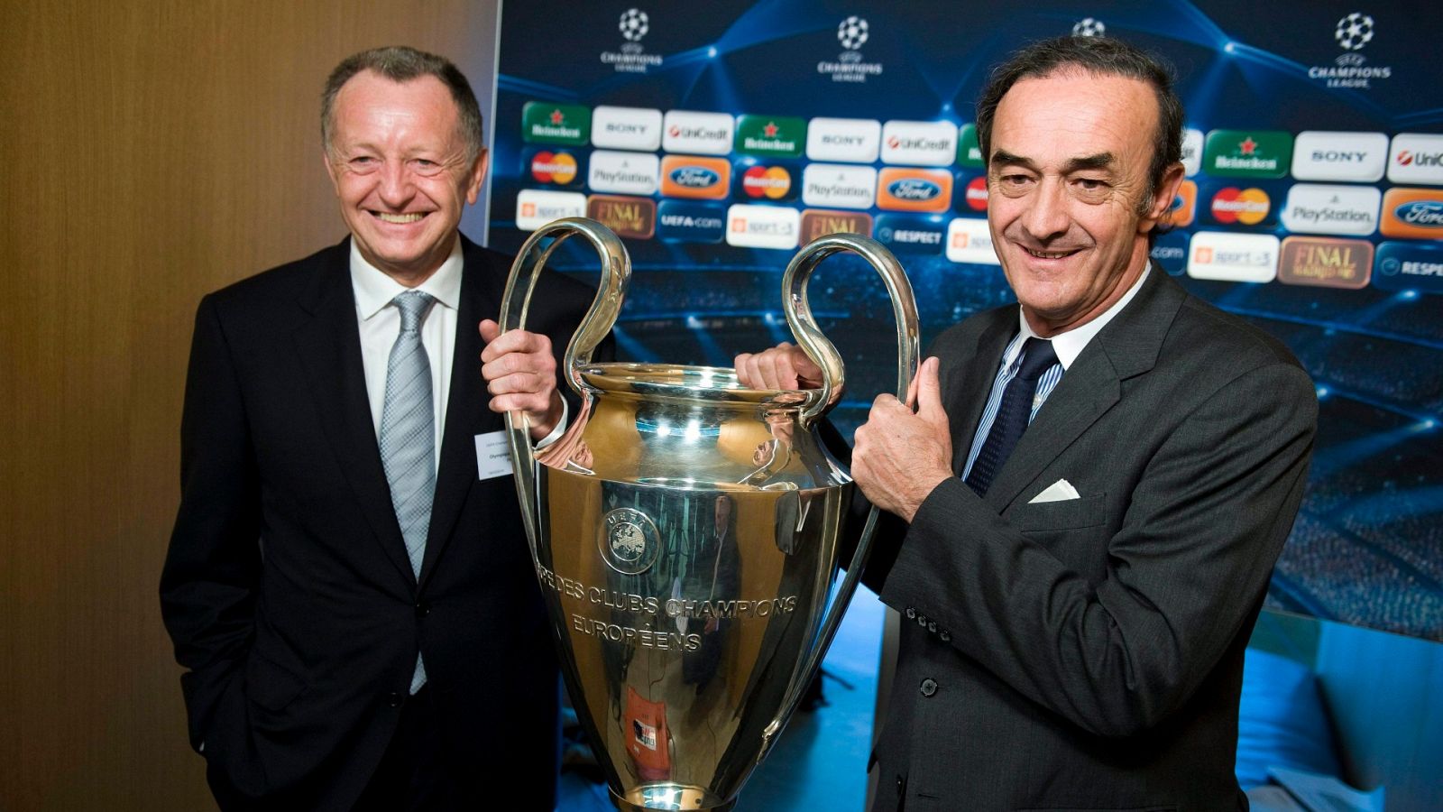 Jean Michel Aulas (i), presidente del Olympique de Lyon, sostiene el trofeo de la Champions League