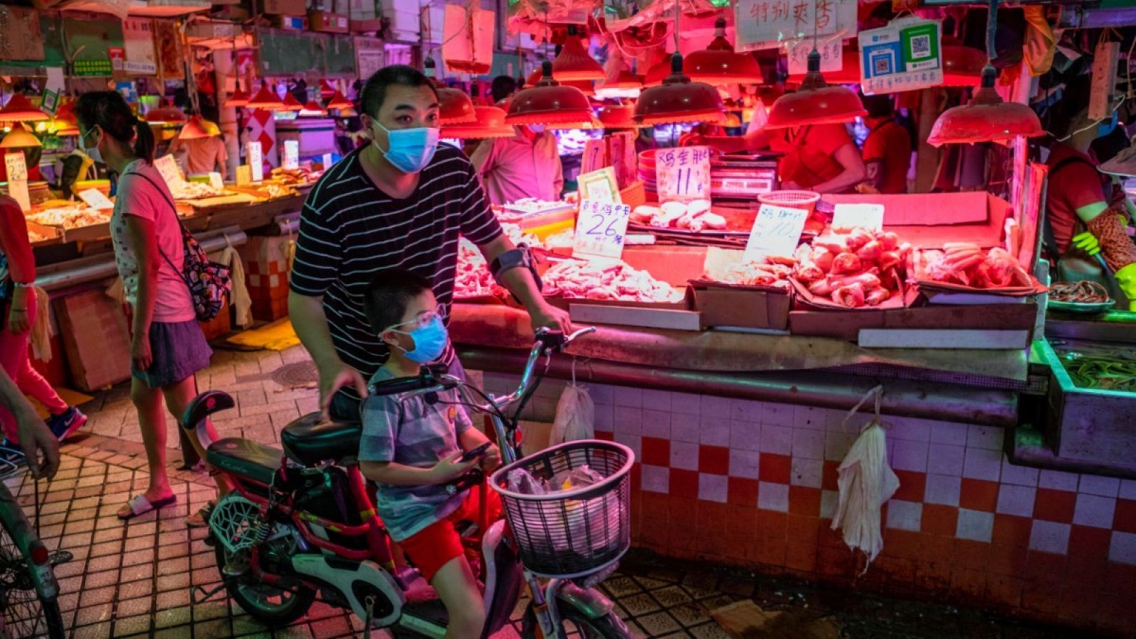 Un hombre con un niño en un mercado de Guangzhou, China.