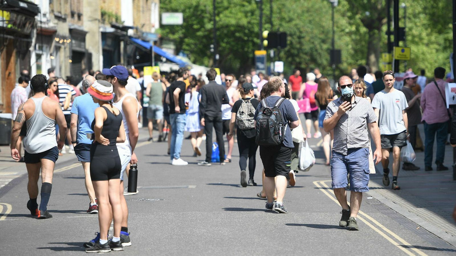 Ciudadanos caminan en el mercado de Broadway en el este de Londres, en Reino Unido, el primer día de alivio de las medidas de co