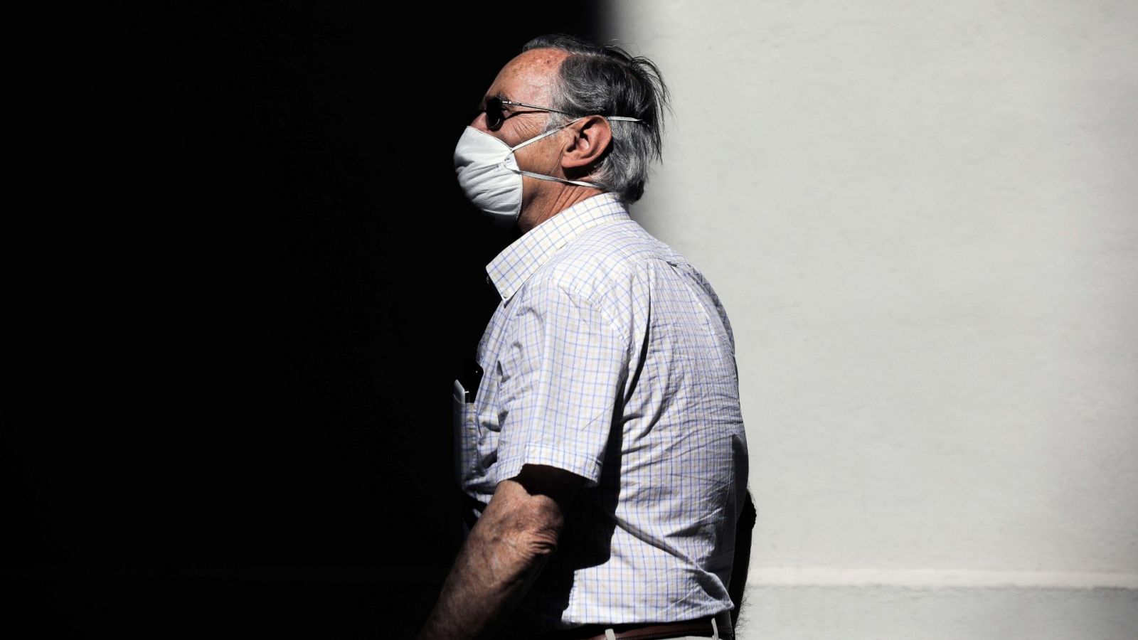 Una persona protegida con mascarilla recorre una calle en Valencia