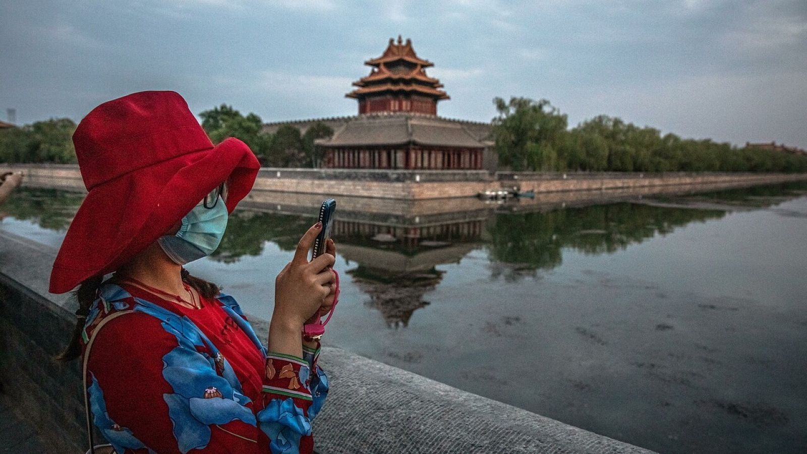 Una mujer con mascarilla en la Ciudad Prohibida, Pekín