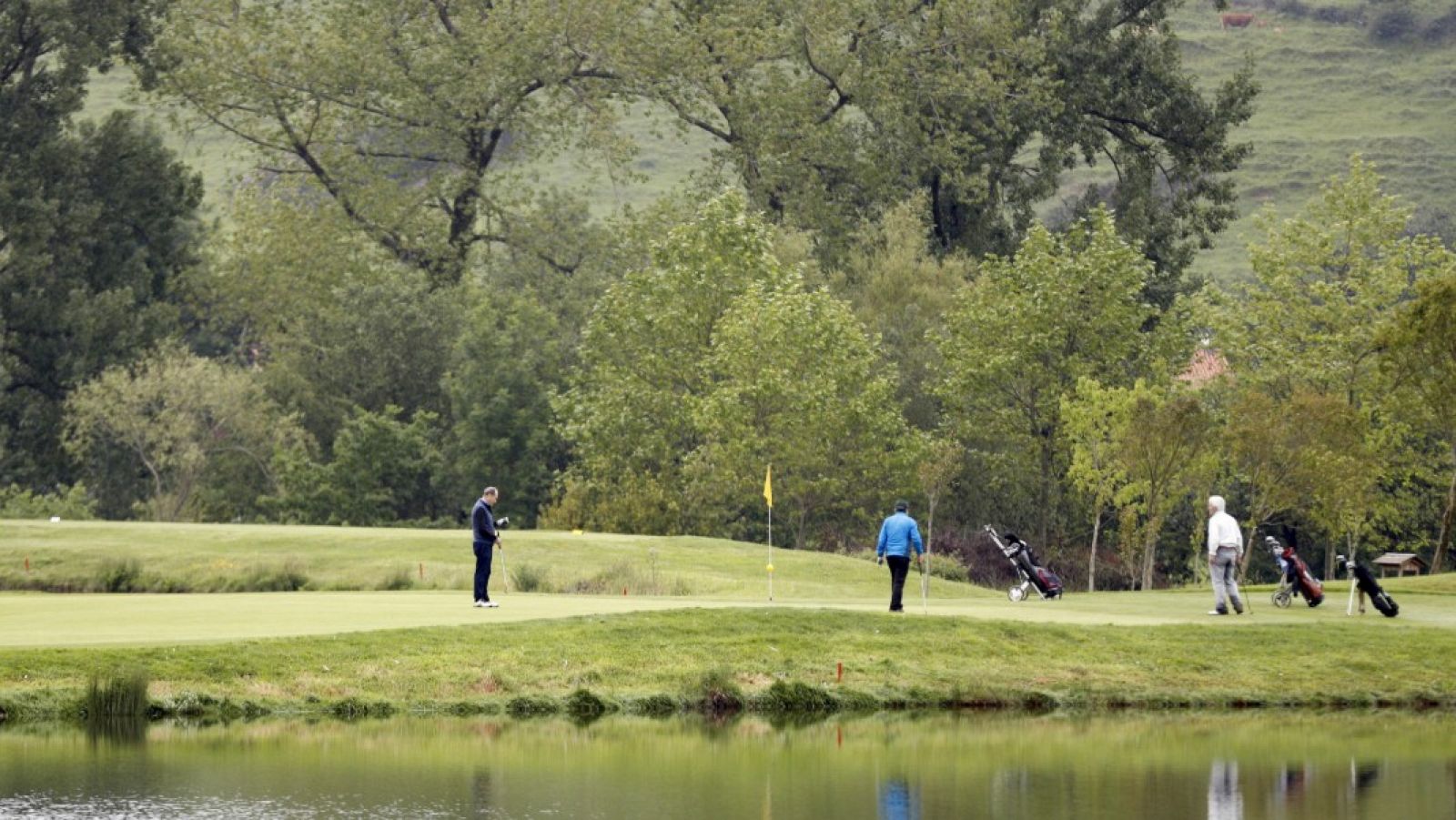 Tres jugadores mantienen la distancia social, en el campo público de golf de Meaztegi en Vizcaya.