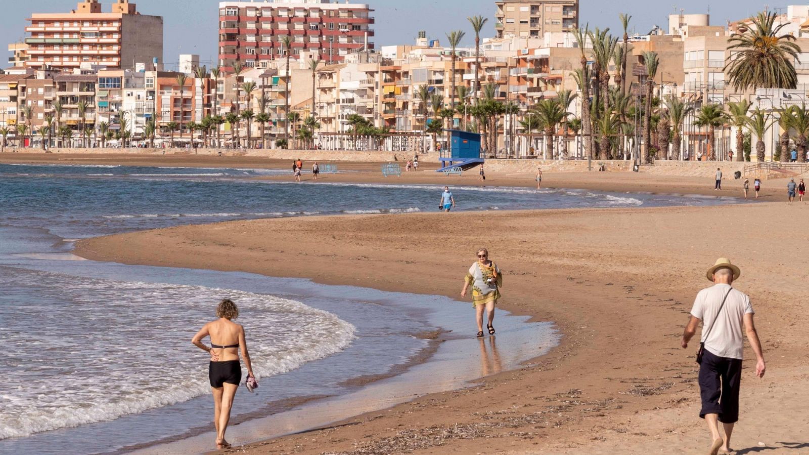 Varias personas pasean por la playa de Rihuete en el municipio murciano de Mazarrón