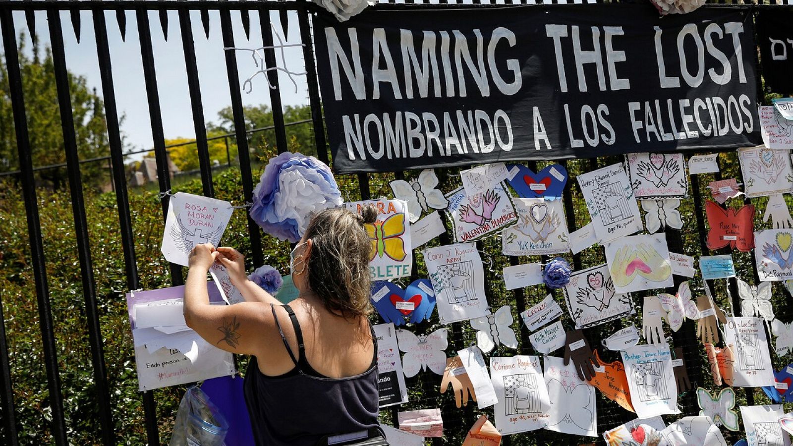 Una mujer añade un nombre al homenaje a las víctimas del coronavirus en el cementerio de Green-Wood