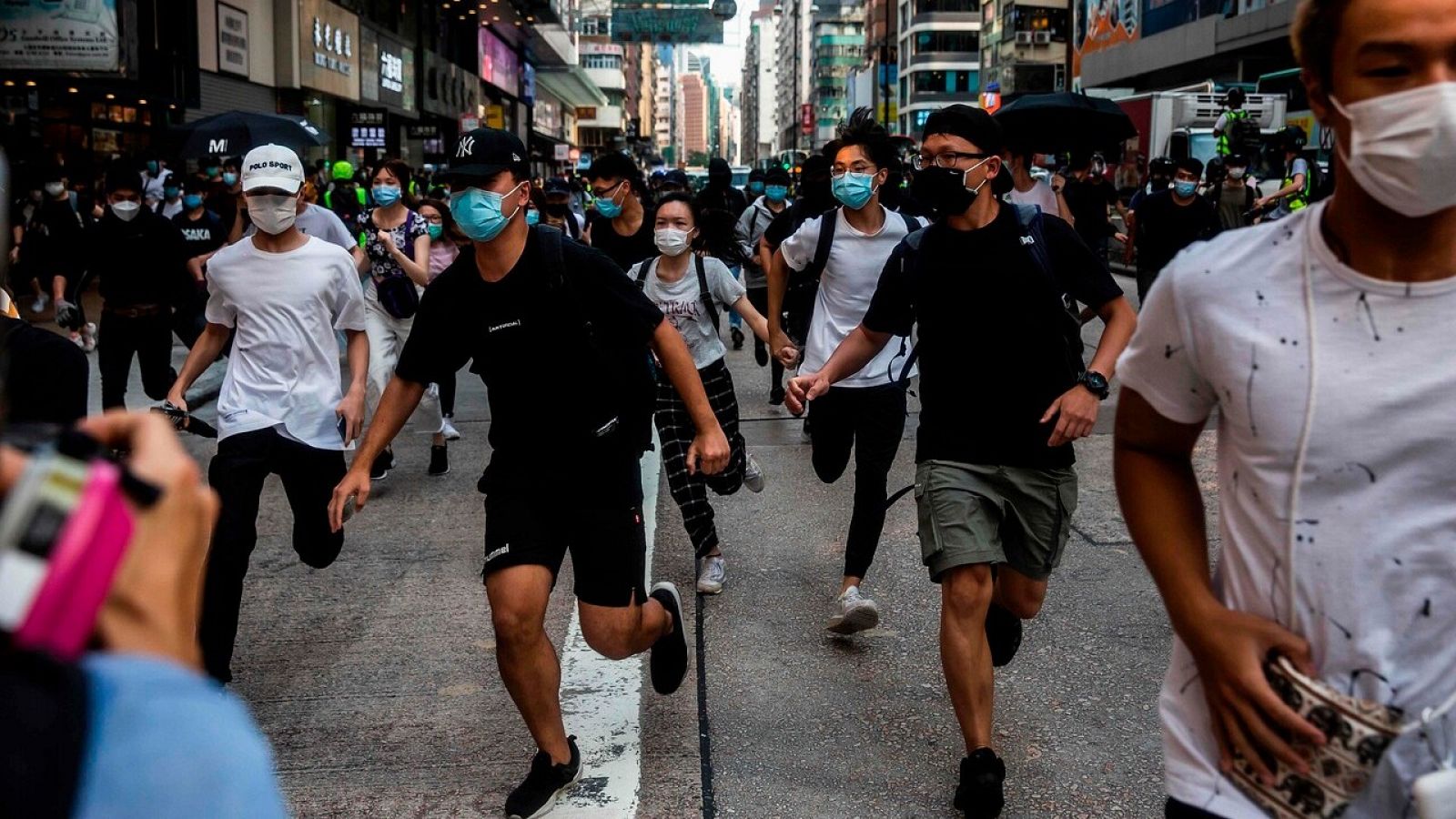 Manifestantes corren ante la llegada de la policía en Hong Kong